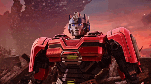 a red robot with blue eyes and the word transformer on the top of his head