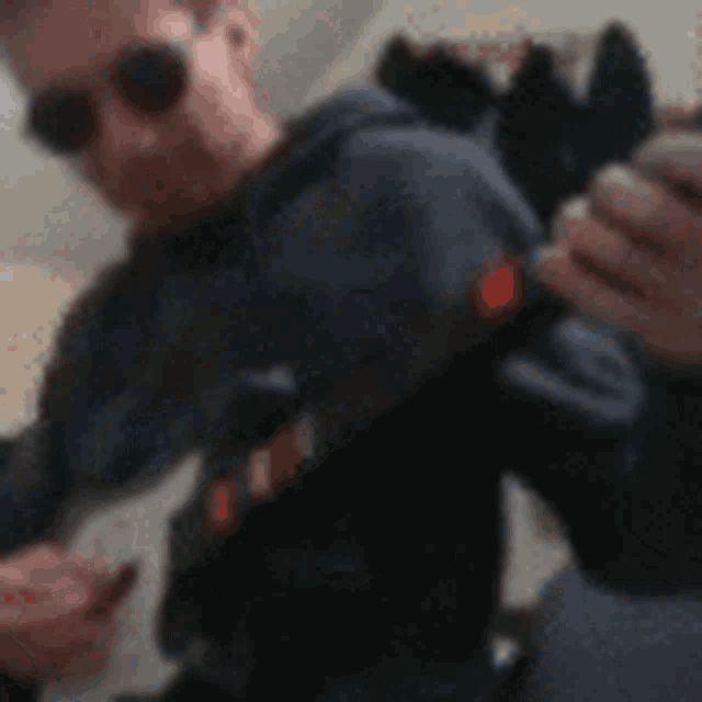 a blurry photo of a man wearing sunglasses and a hoodie