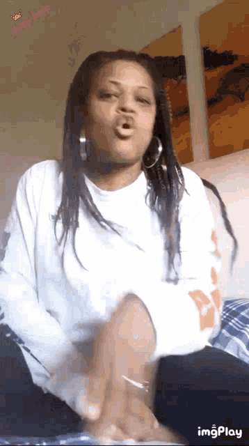a woman is making a funny face while wearing a white sweater