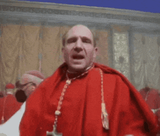 a man in a red robe with a cross necklace