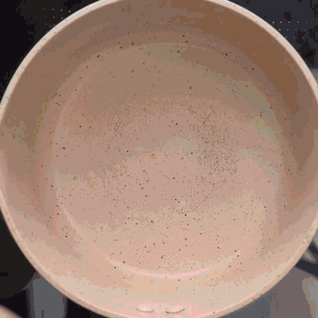 a white bowl with black spots on it is sitting on a table