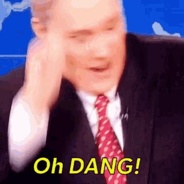a man in a suit and tie is saying oh dang !
