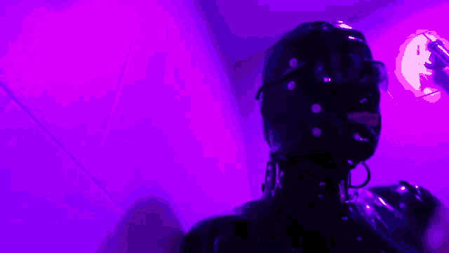 a person wearing a mask and sunglasses is standing in front of a purple background