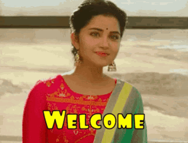 a woman in a pink dress is standing next to a sign that says welcome