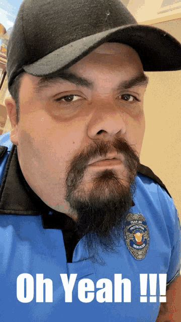 a man with a beard and mustache wearing a blue shirt that says ' oh yeah ' on it
