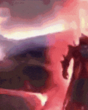 a blurry picture of a person standing in front of a red background