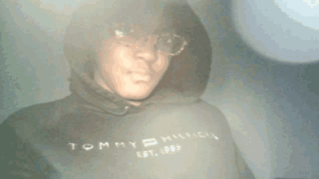 a person wearing a tommy hilfiger hoodie with a hood