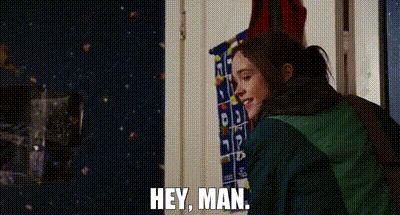 a woman in a green jacket is standing in a room and talking to another woman .