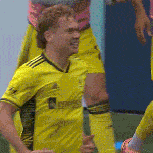 a soccer player wearing a yellow jersey that says adidas