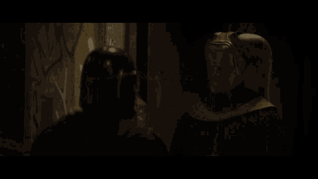 a man in a black helmet is standing next to another man in a yellow robe