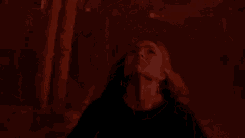 a woman in a black shirt is looking up at a painting