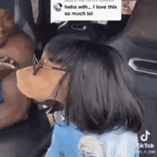 a woman wearing a face mask and sunglasses is sitting in a car .