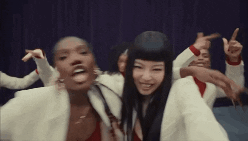 a group of women are dancing together on a stage and making funny faces .