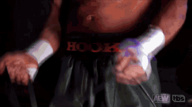 a man with hook written on his shorts is wrapping his hands