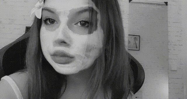 a black and white photo of a woman with a face mask on her face .