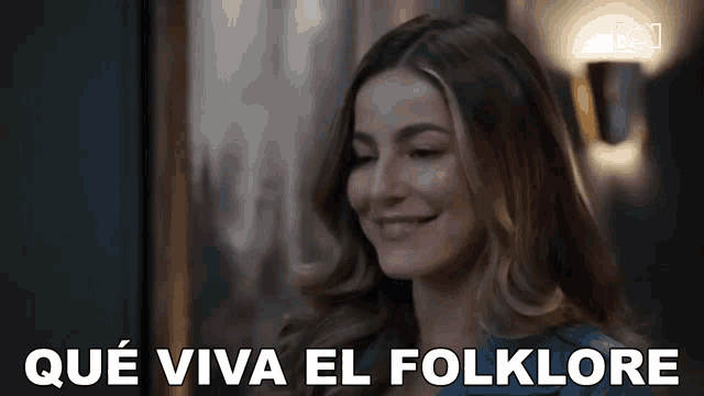 a woman is smiling and the words que viva el folklore are visible