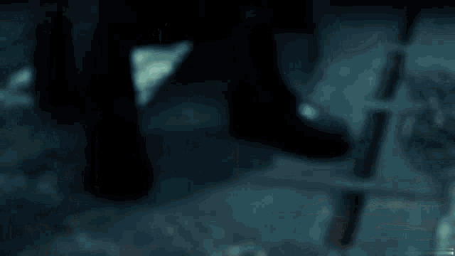 a person in a black cape stands in a dark room