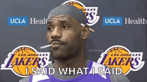 a man smoking a cigarette in front of a lakers logo
