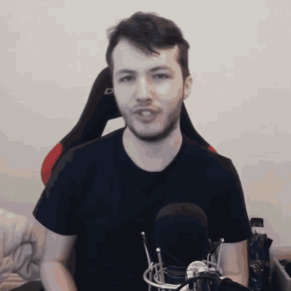 a man with a beard is sitting in front of a microphone and talking