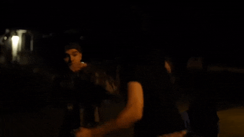 a group of people are dancing in a dark room .