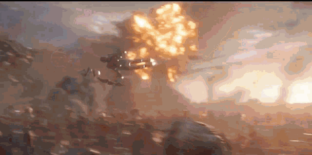 a group of people are standing in front of a large explosion .