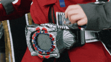 a person wearing a red jacket and a silver belt with a circular object on it