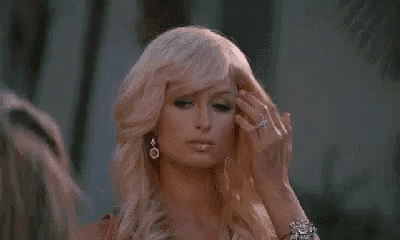a close up of a woman with blonde hair and earrings .