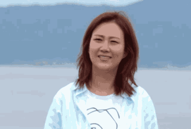 a woman in a blue shirt with a drawing of a face on it
