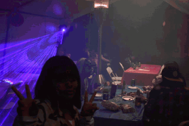a woman giving a peace sign in front of a table