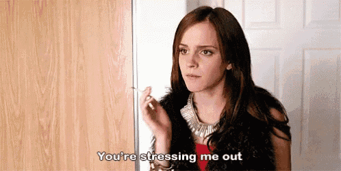 a woman is standing in front of a door smoking a cigarette and saying `` you 're stressing me out ''