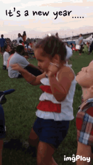 a little girl dancing in a field with the words it 's a new year below her