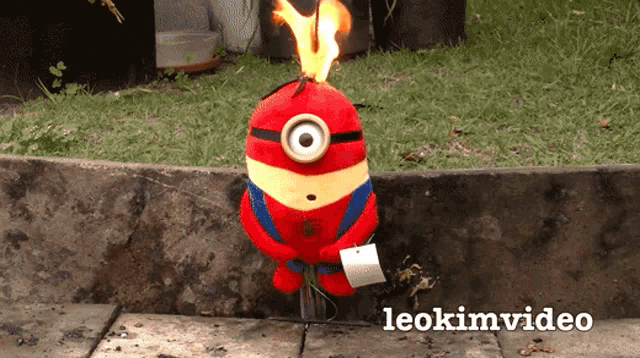 a stuffed minion with flames coming out of it 's head and the words leokimvideo below it