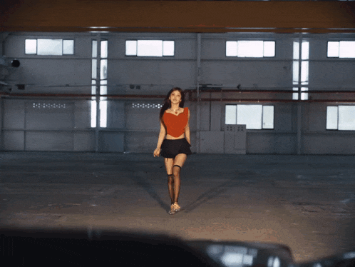 a woman in an orange top and black skirt