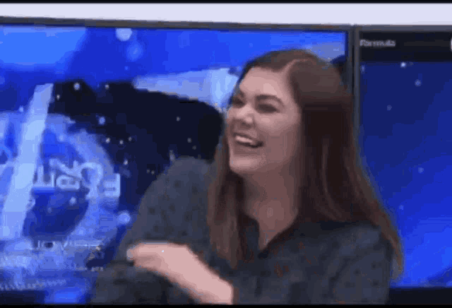 a woman is laughing in front of a television screen that says formula