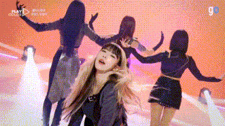 a group of women are dancing on a stage with the words play visible in the background
