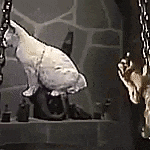 a statue of a cat is sitting on a shelf next to a statue of a hand .