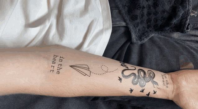 a person has a tattoo on their arm that says ' in the heart '