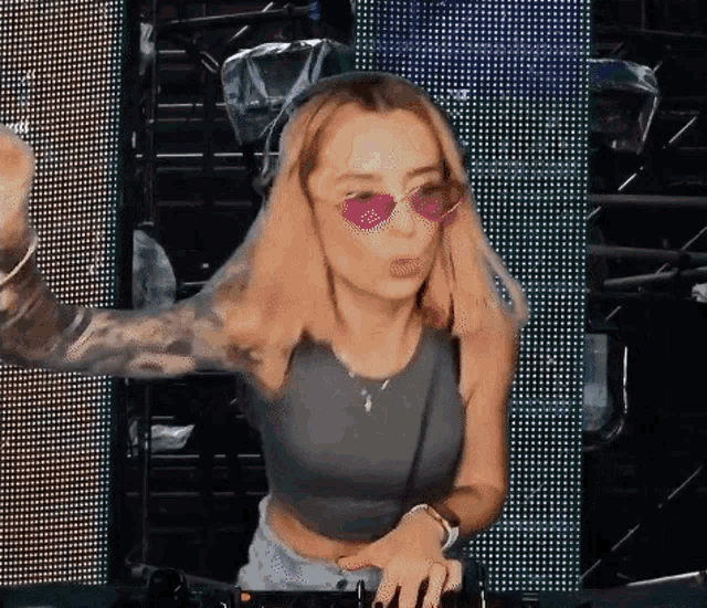 a woman wearing sunglasses and a crop top is dancing