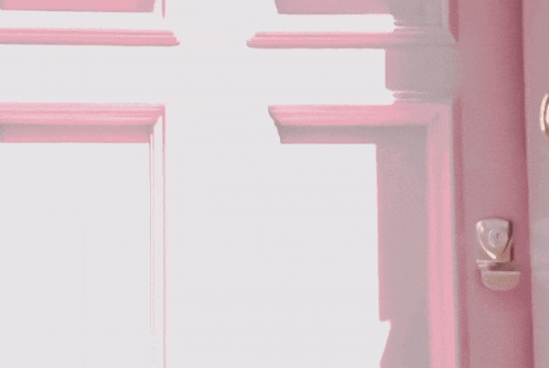 a close up of a pink door with a light shining through it