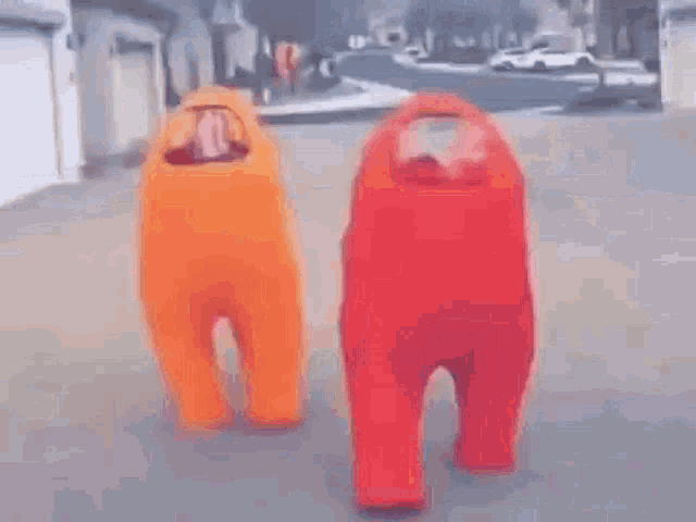 two among us characters are standing next to each other on the street .
