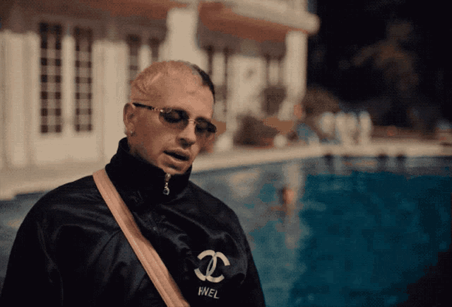 a man wearing sunglasses and a chanel jacket