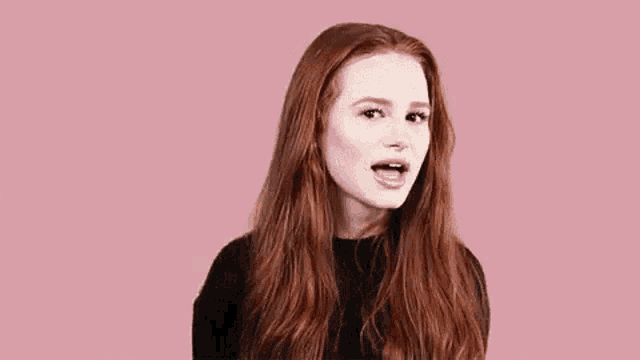 a woman with red hair is yawning with her mouth wide open .