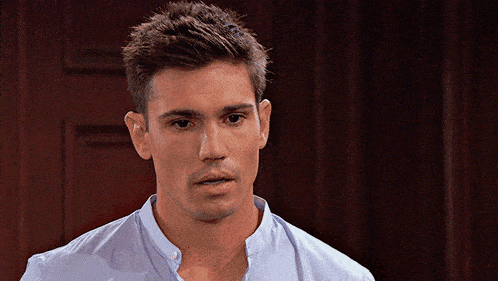 a man in a blue shirt stands in front of a door