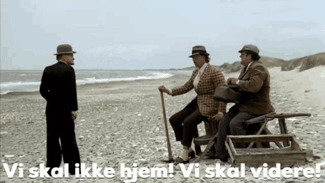 three men standing on a beach with the words vi skal ikke hjem written below them