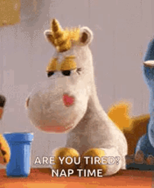 a stuffed unicorn from toy story is sitting on a table and says `` are you tired? nap time '' .