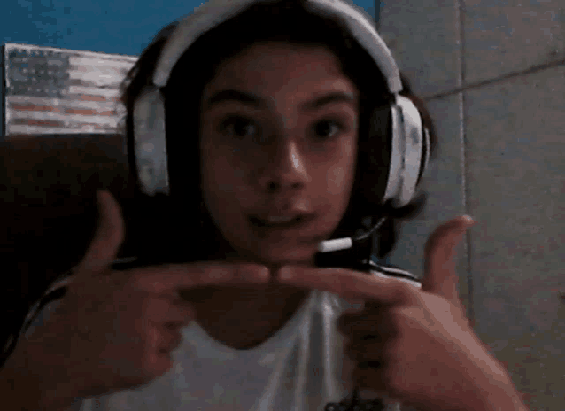 a girl wearing headphones and a white shirt with the word adidas on it