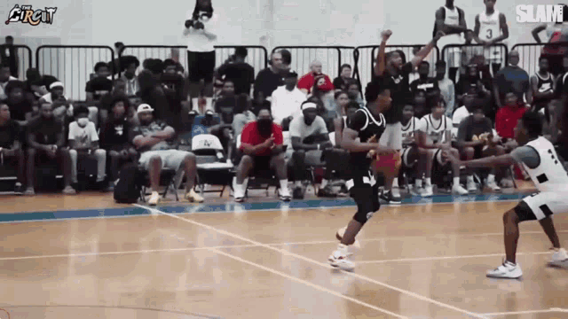 a basketball game is being played in front of a crowd with the word slam at the bottom