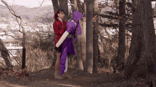 a woman in a purple outfit is standing next to a woman in a red outfit