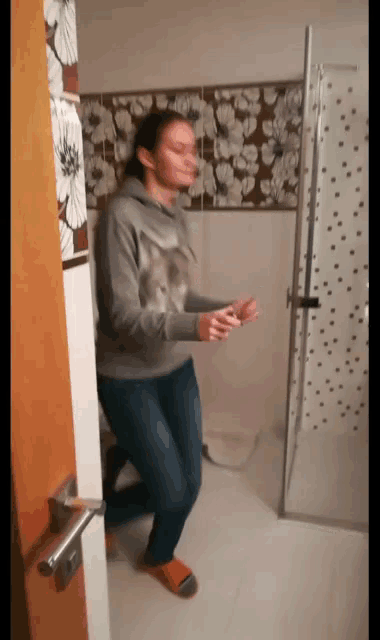 a blurry picture of a woman standing in a bathroom with flowers on the wall