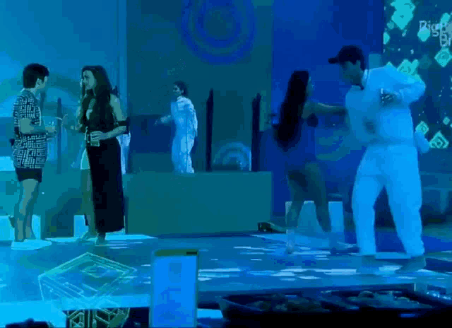 a group of people are dancing in a dark room with a sign that says big brother on it